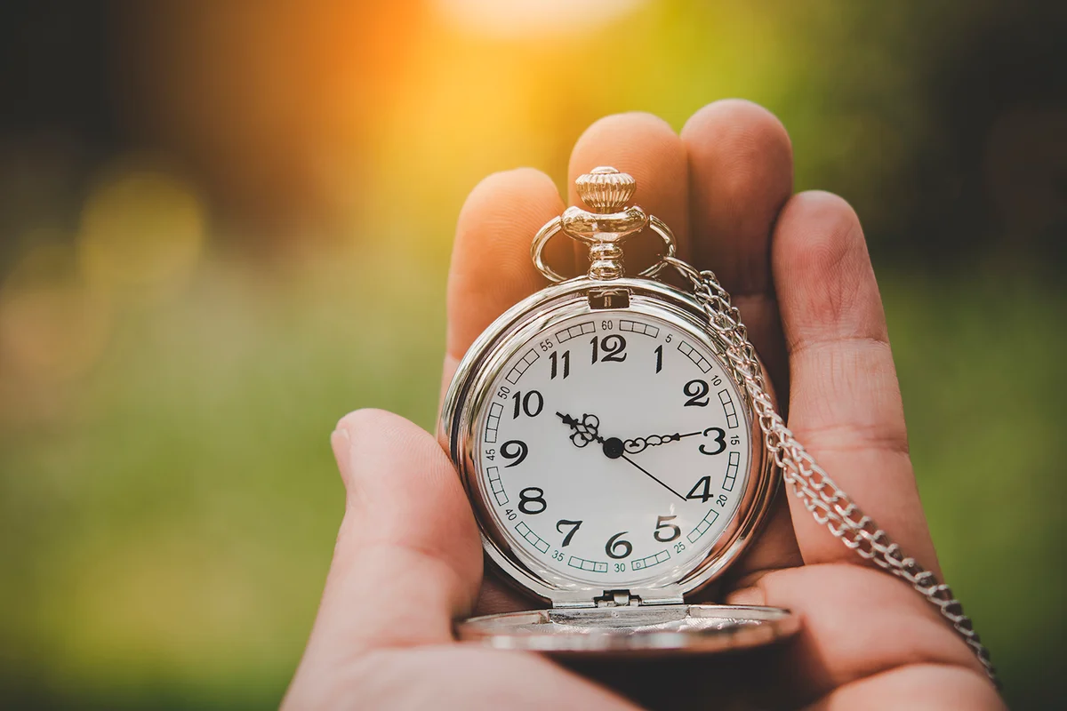 Hand holding retro stopwatch in natural background.
