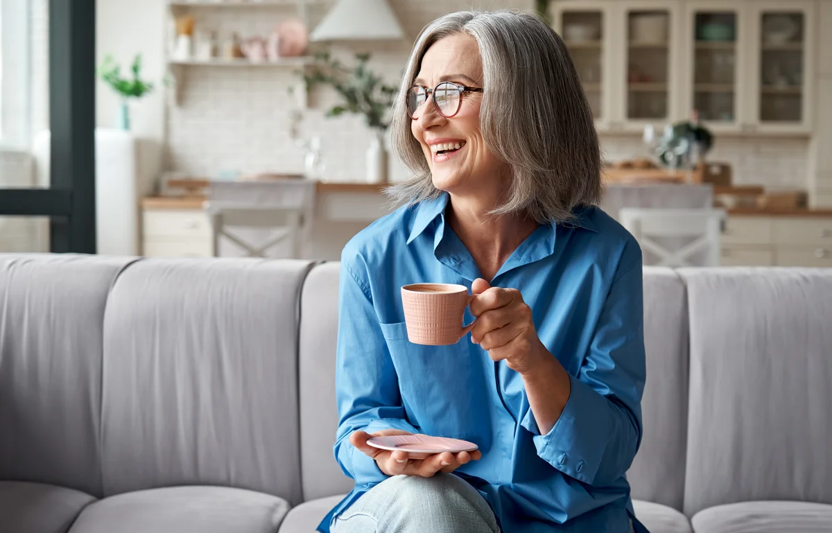 Woman with gray hair drinking coffee
