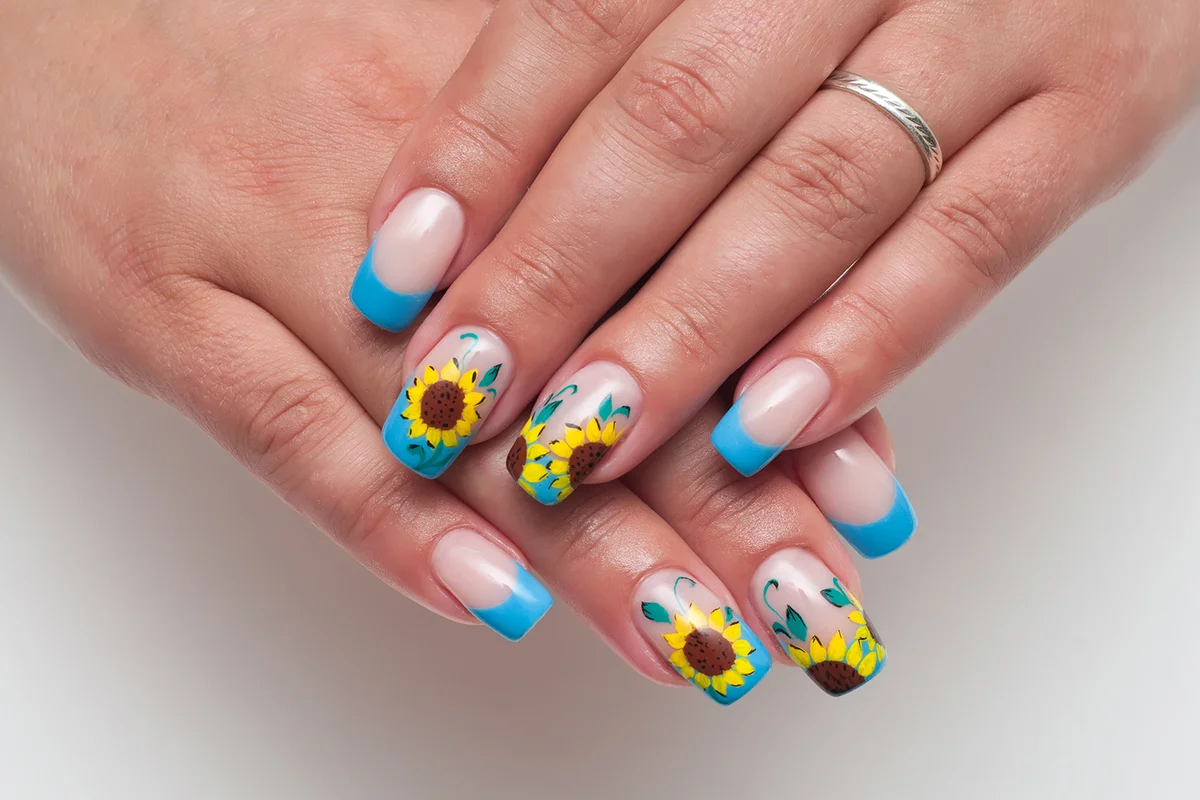 French blue manicure with painted sunflowers