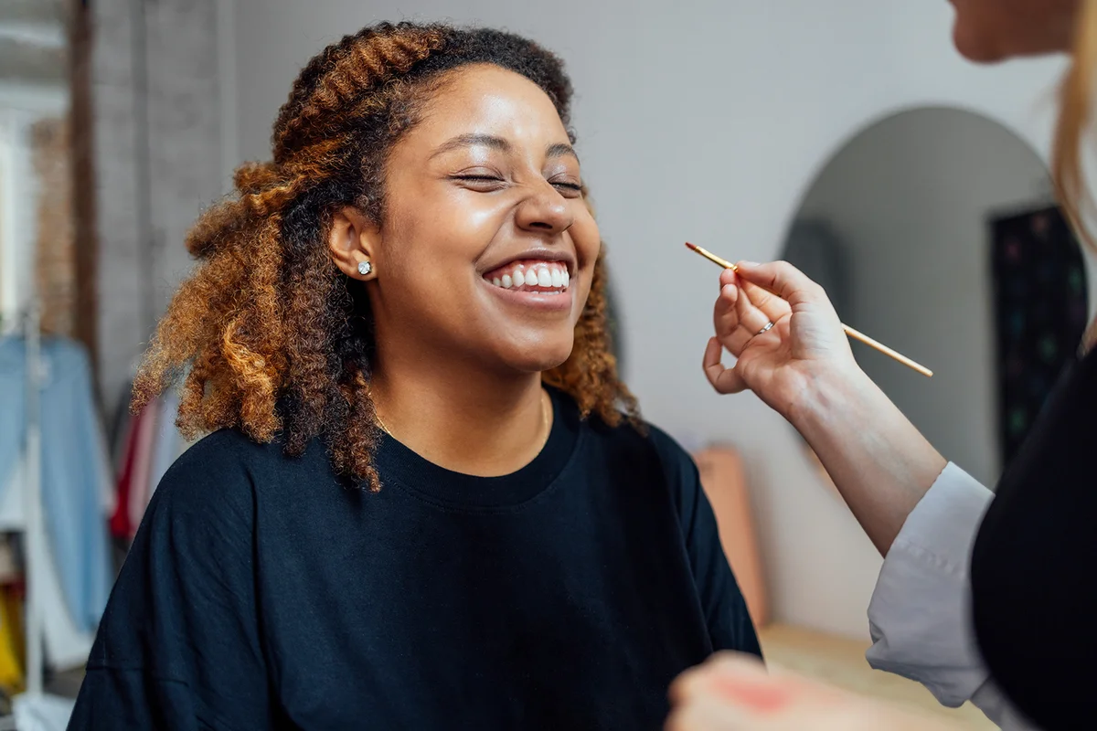 woman makes makeup for her client in a beauty salon