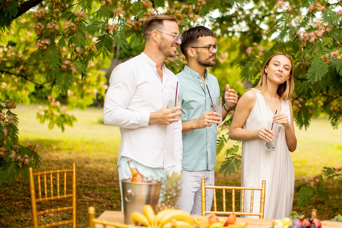 friends with fresh lemonade and eating fruits in the garden