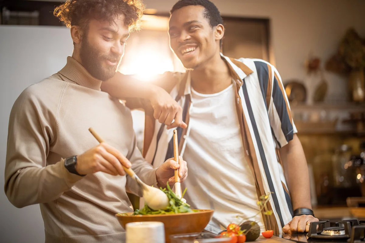 couple having fun while making salad together on kitchen