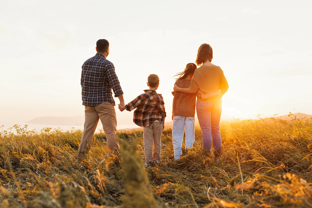Family stands on sunset