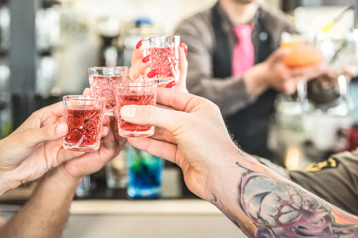 friends toasting cocktails at bar
