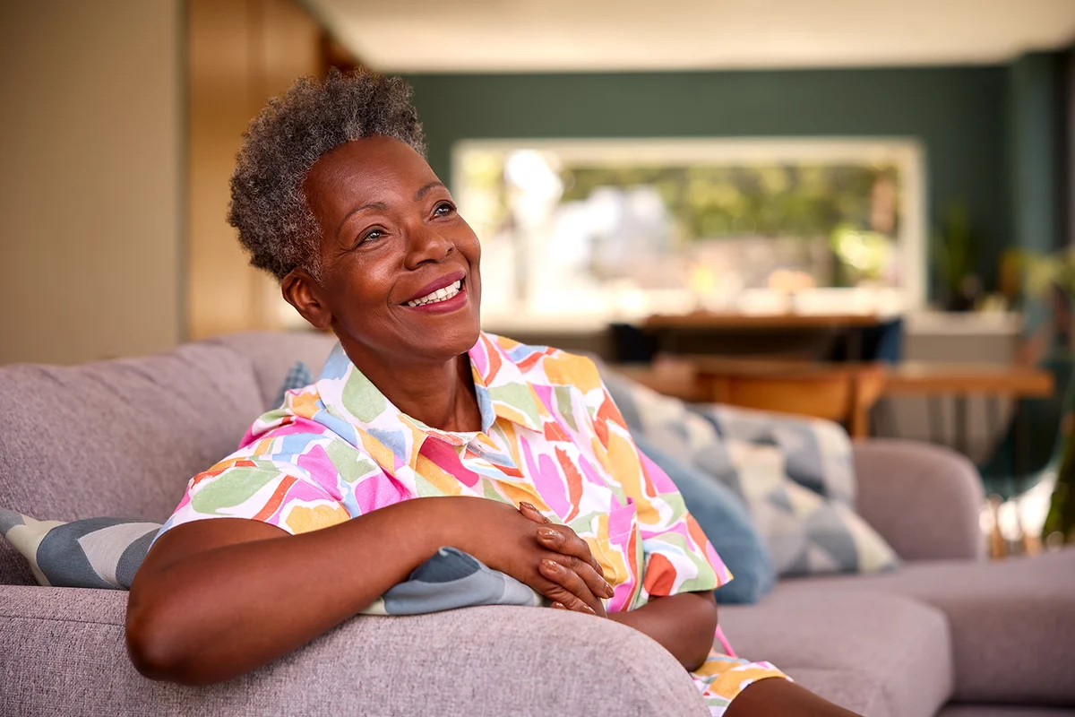 Senior Woman Relaxing On Sofa At Home
