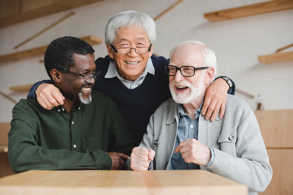 group of senior friends embracing in bar