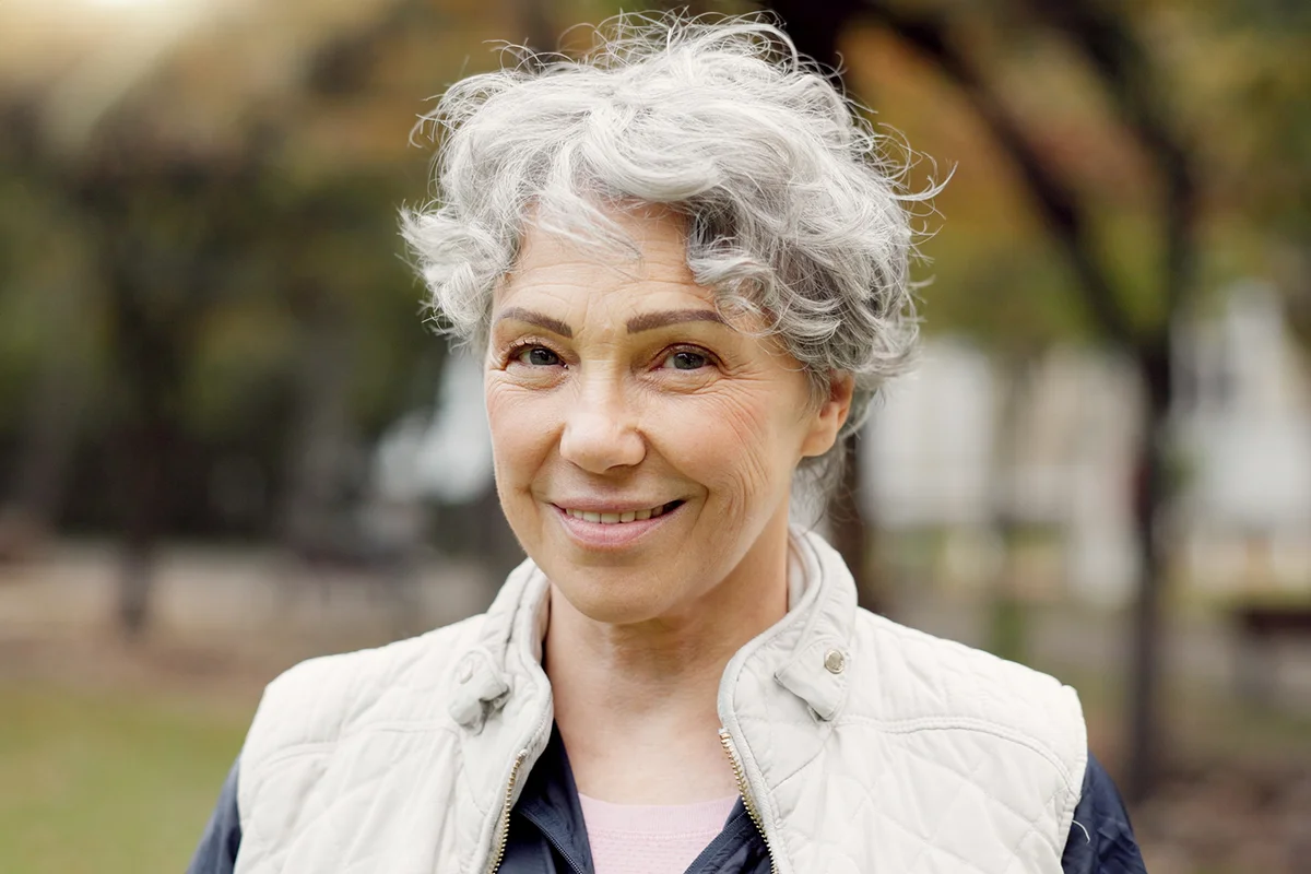 senior woman and smile in the park with happiness in nature