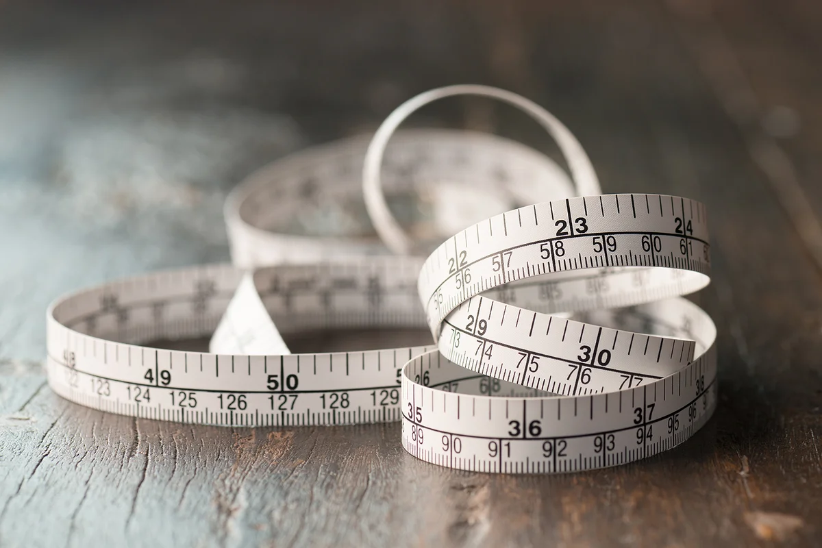 tailor measuring tape on wooden table