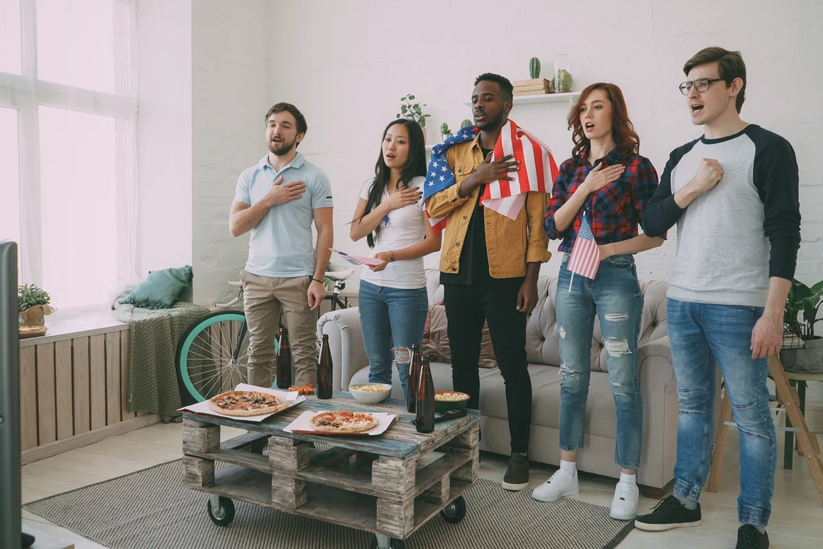 friends sport fans singing national USA anthem before watching sports championship
