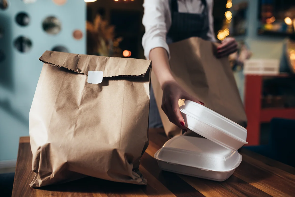 woman waitress preparing take away food in restaurant