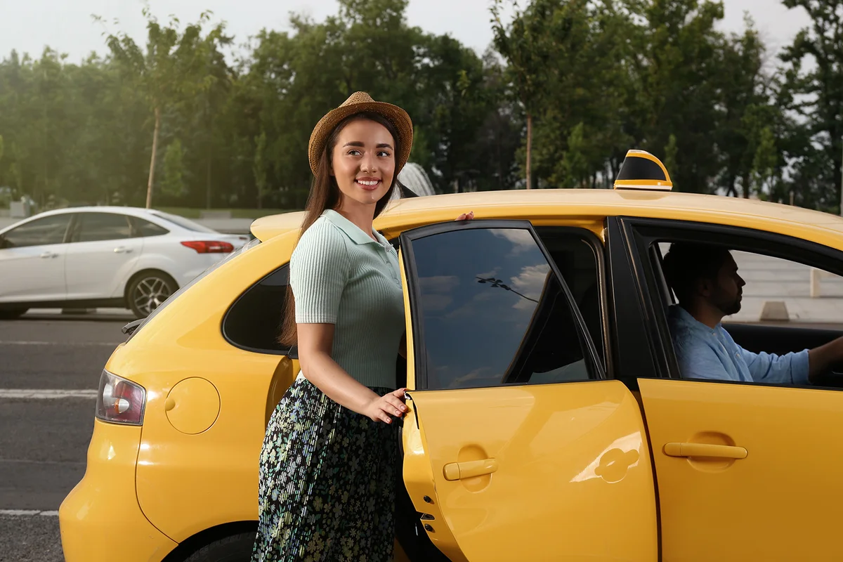 woman getting in taxi on city street