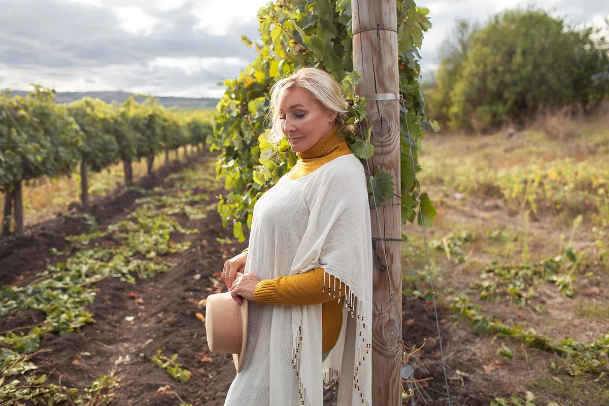 middle aged woman with a beautiful view of vineyards and mountain
