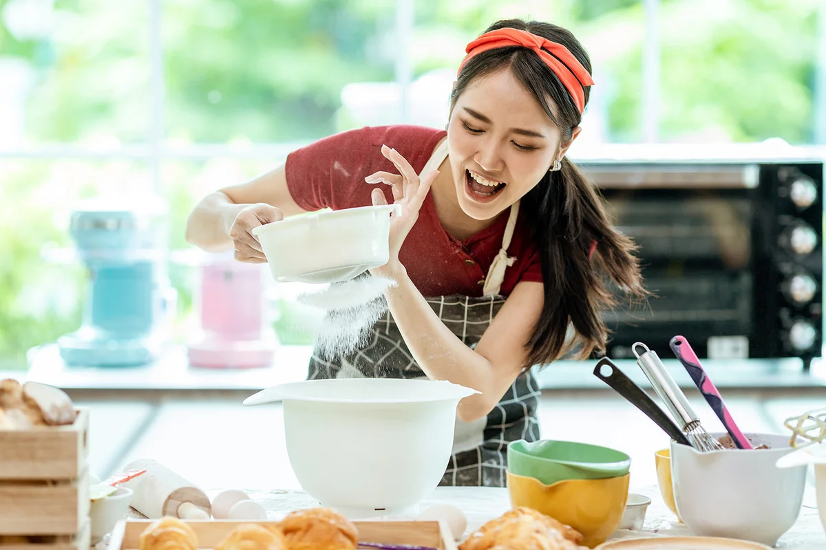 beautiful Asian woman Have fun sifting wheat flour make bread.
