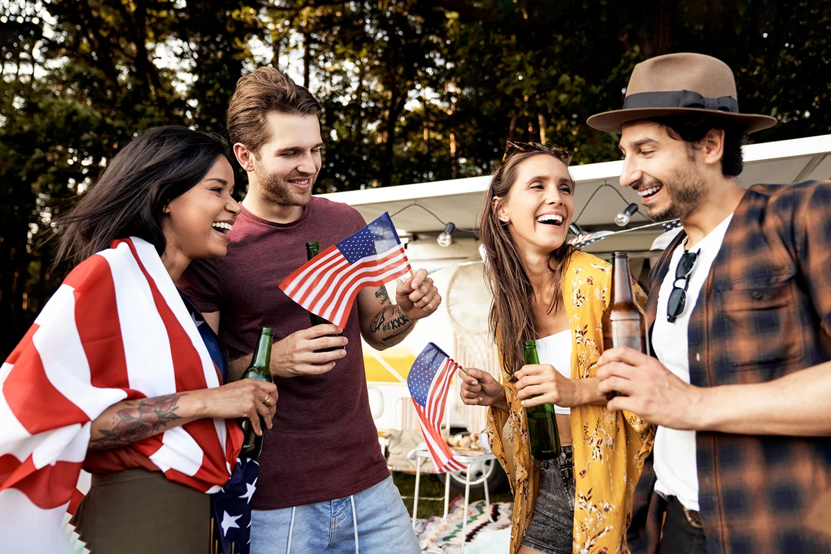 Group of young friends celebrating 4th of July on the camping