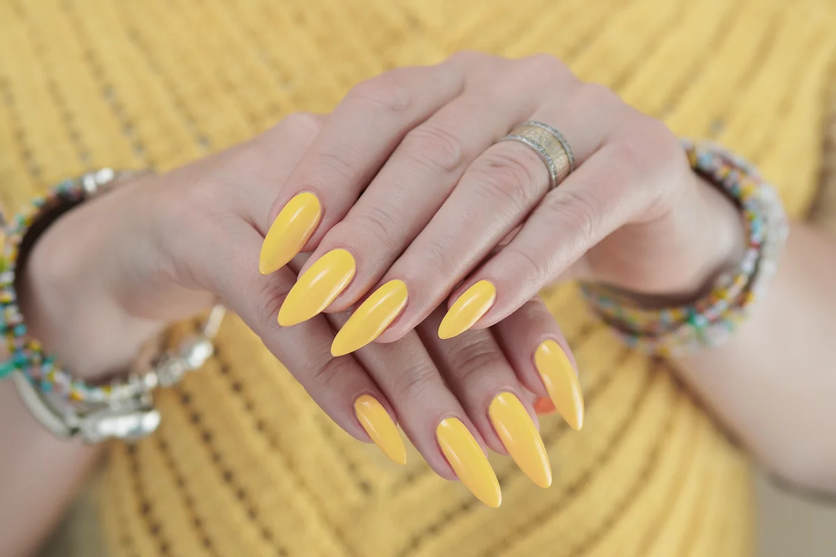 Female hand with long yellow nails