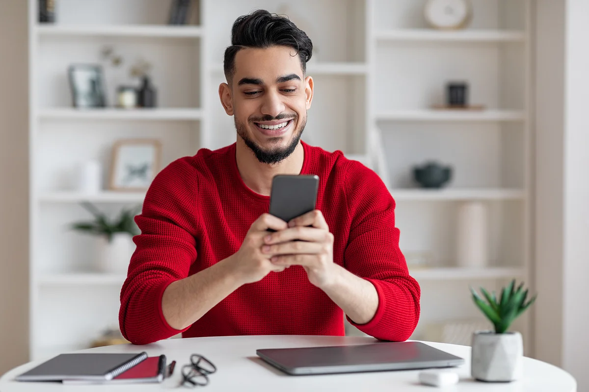 Man Using Smartphone While Sitting At Desk