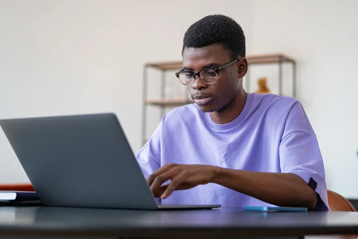businessman in eyeglasses typing on laptop