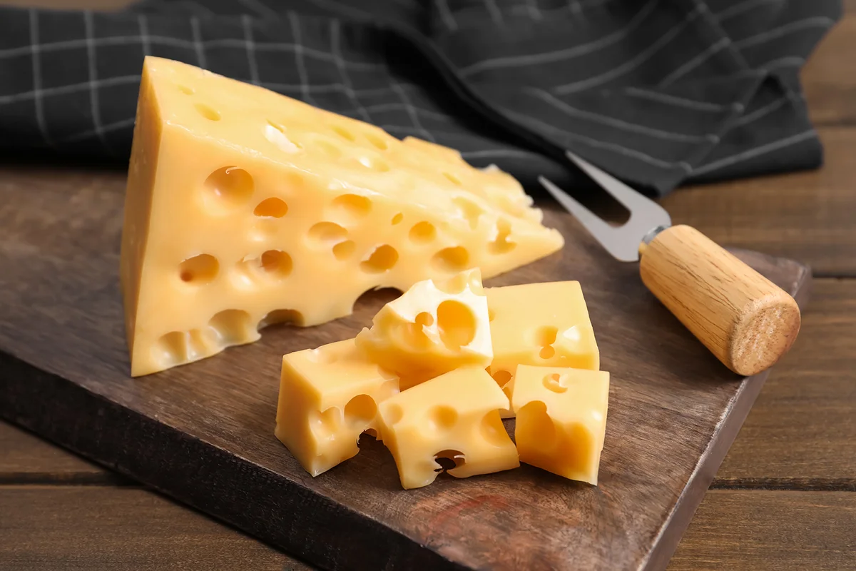 Tasty fresh cheese with fork on wooden table