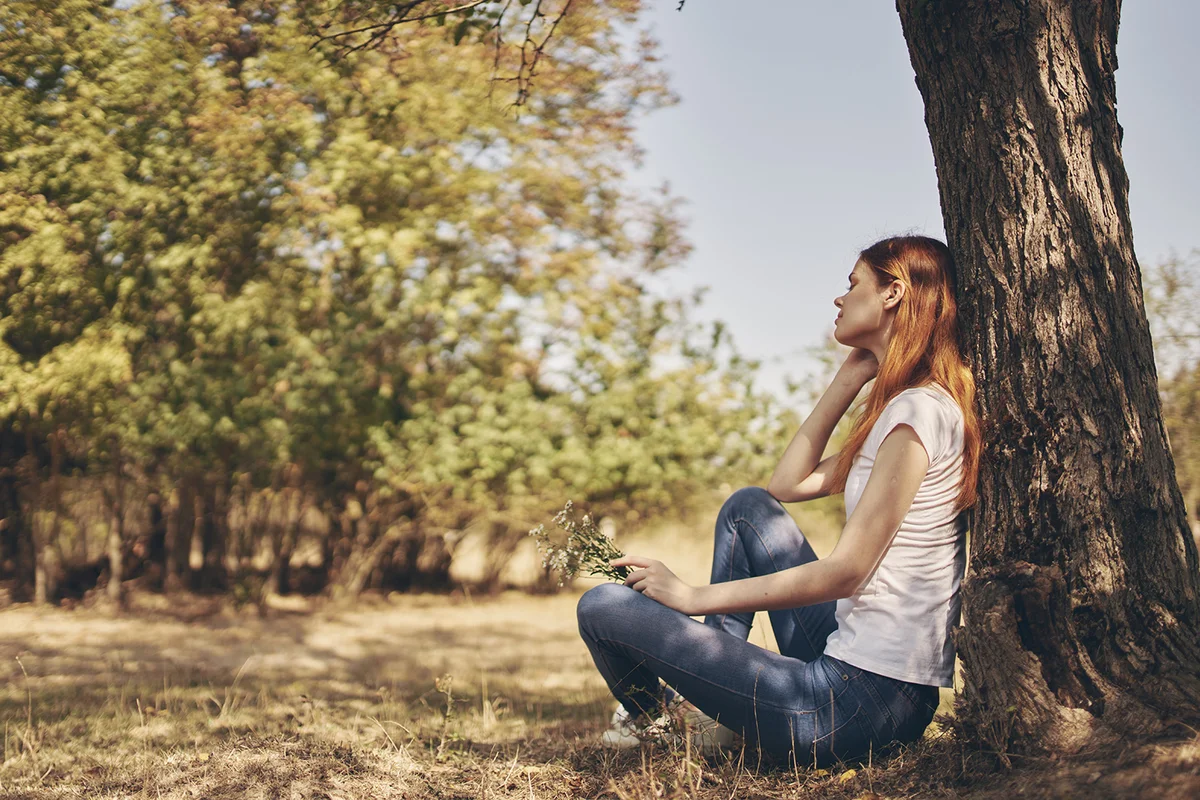 woman squatting on a tree