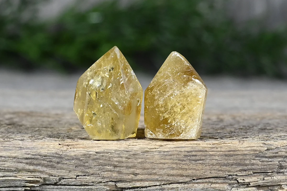 Natural golden yellow citrine tower crystal gemstone on wooden shelf