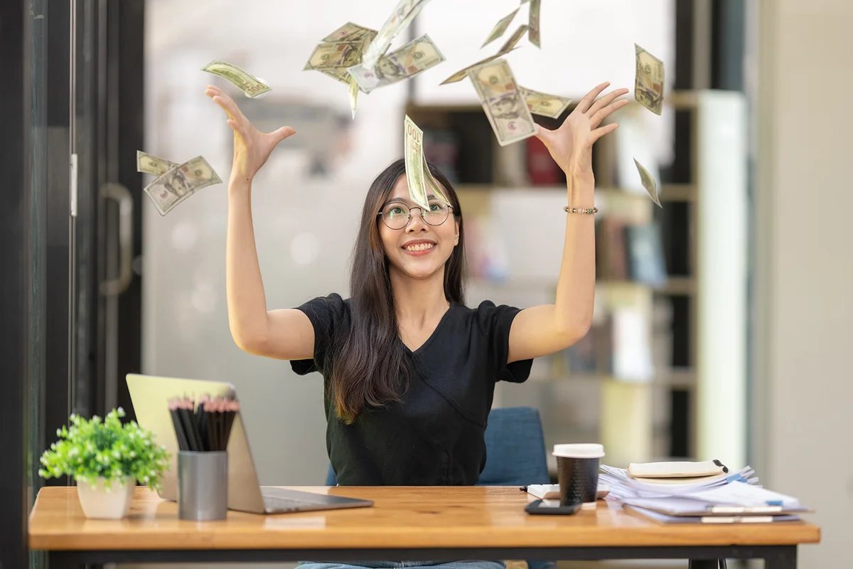 impressed business woman having a lot of flying money around her,