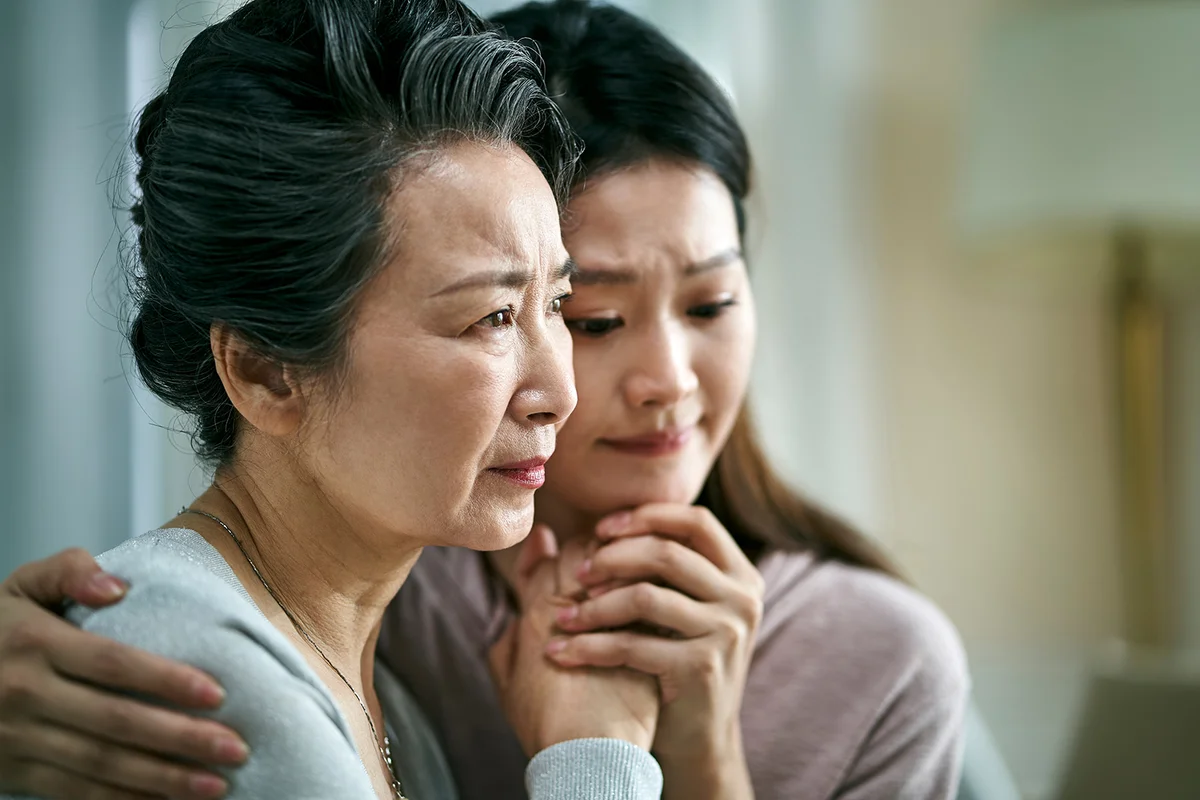 grieving mother and daughter holding hands