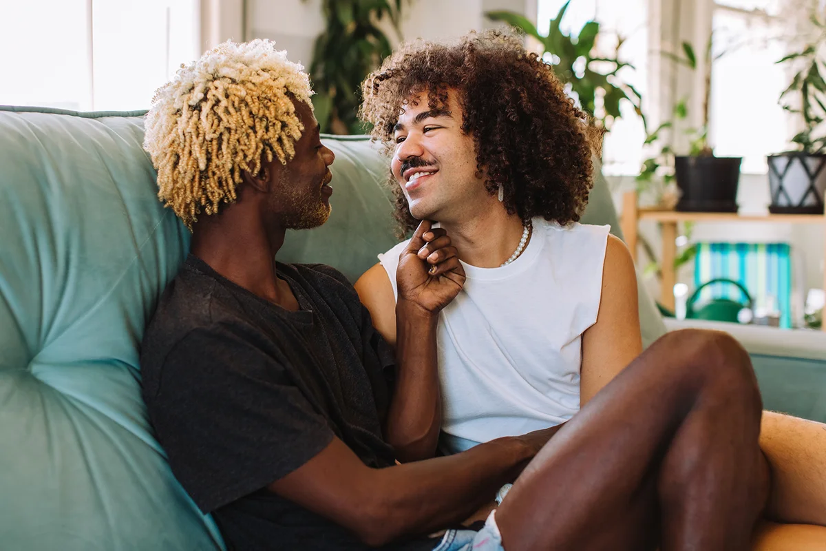Young gay couple being romantic indoors.