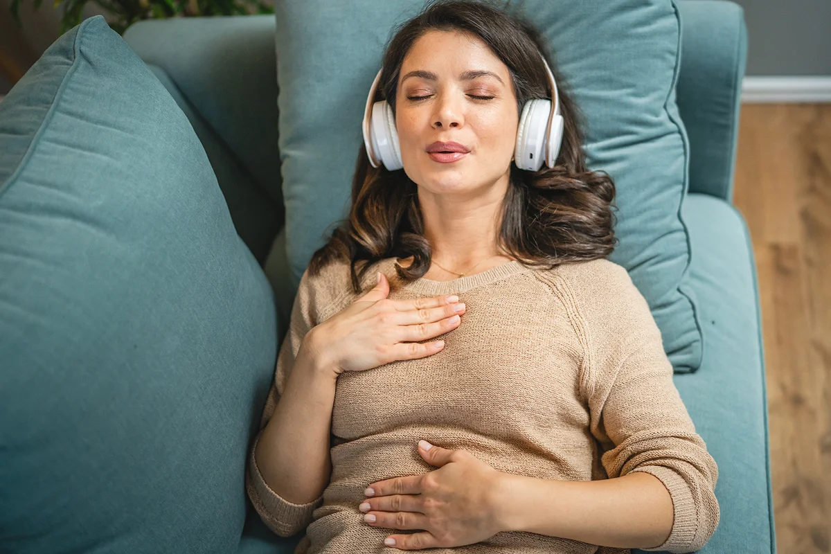 woman using headphones for online guided meditation
