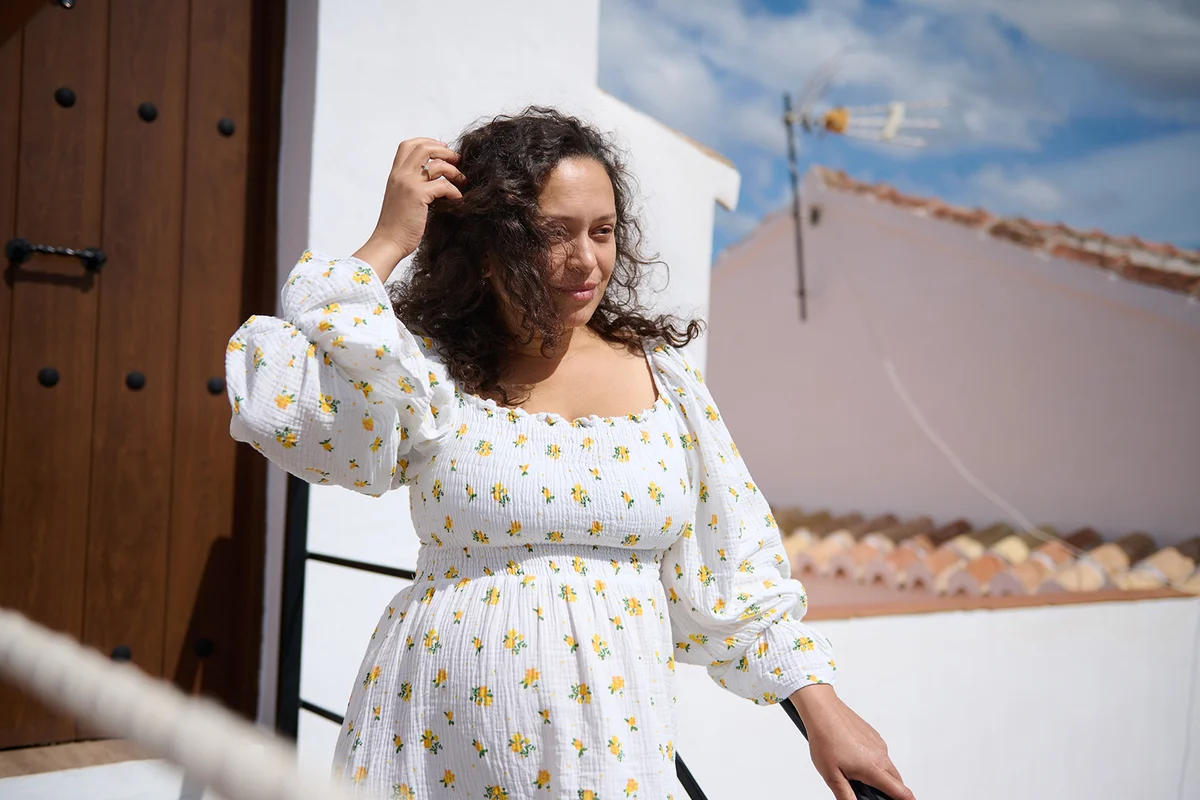 woman with curly hair and a floral dress