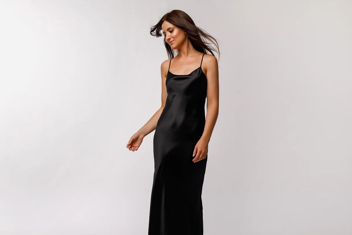 woman black slip dress on a light background