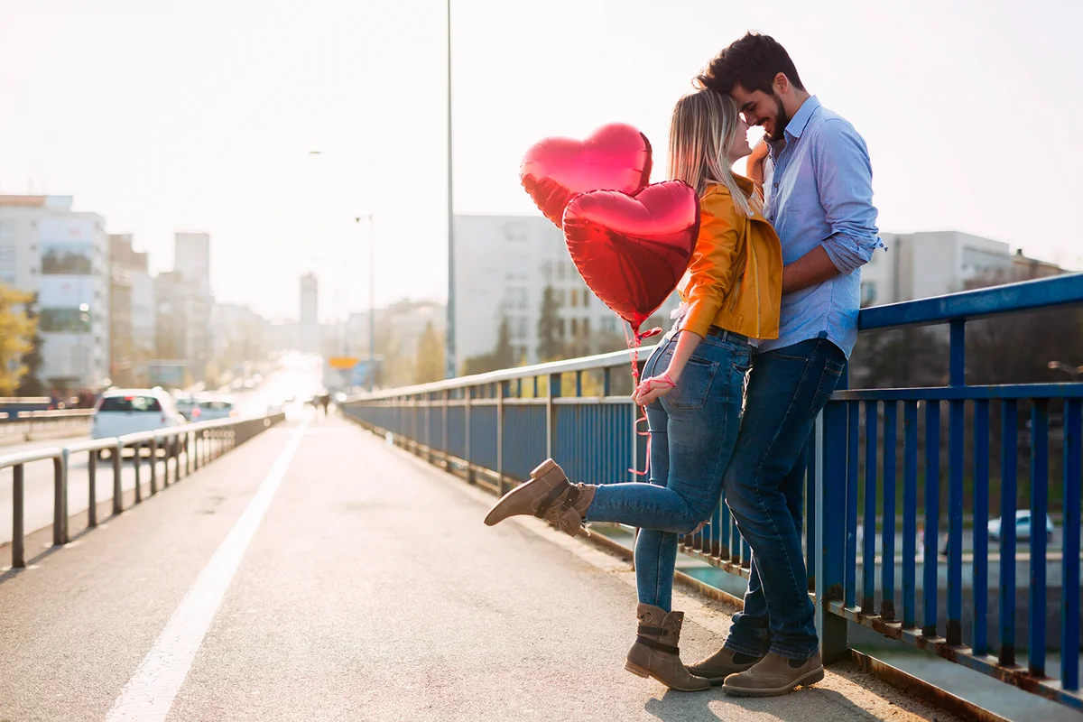 Couple in love cuddling while enjoying beautiful urban sunset together