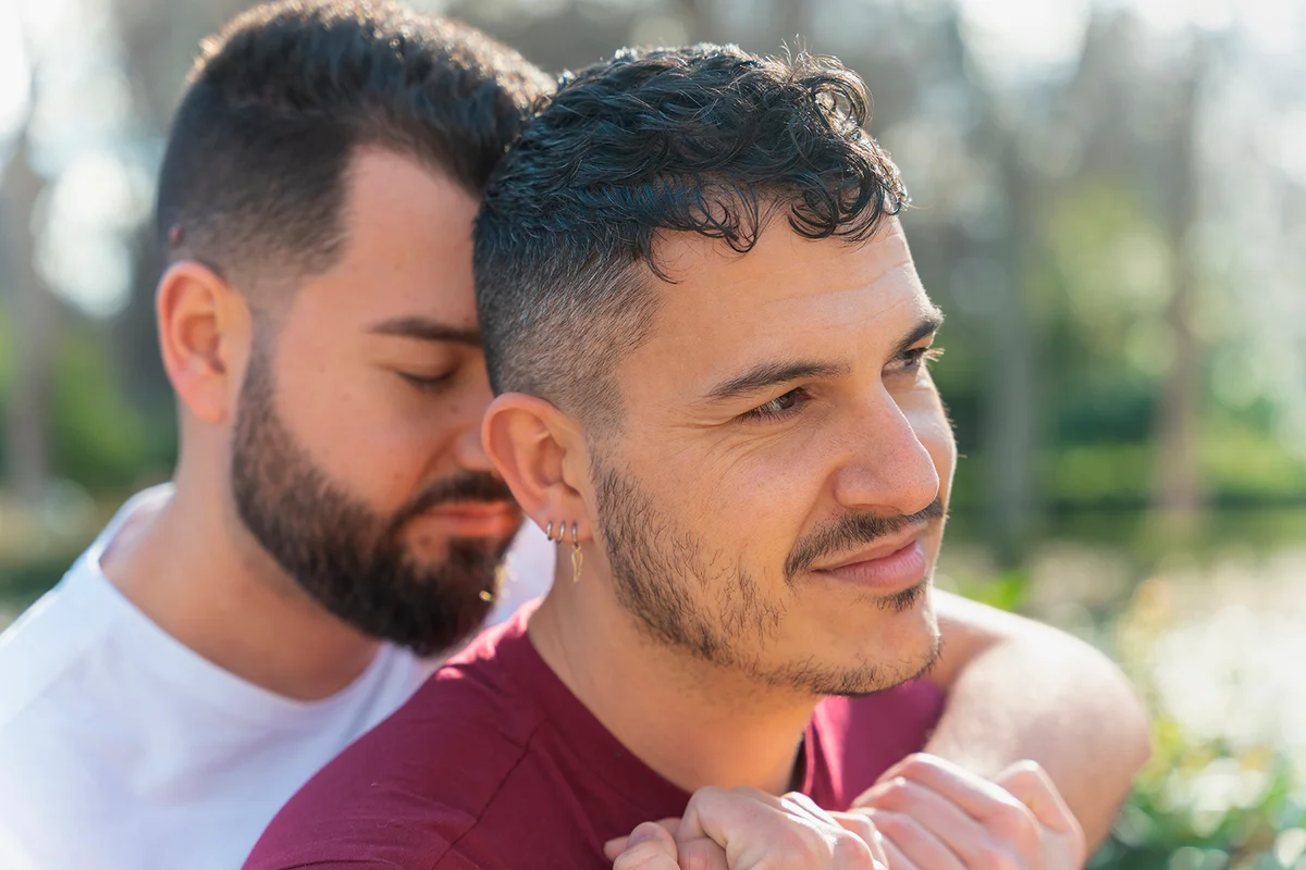 gay couple in the park, cuddling, loving and playful