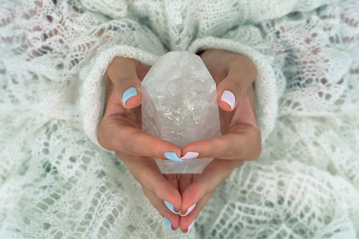 Woman's hands holding crystal. Concept of occult symbolism and spiritual practice.