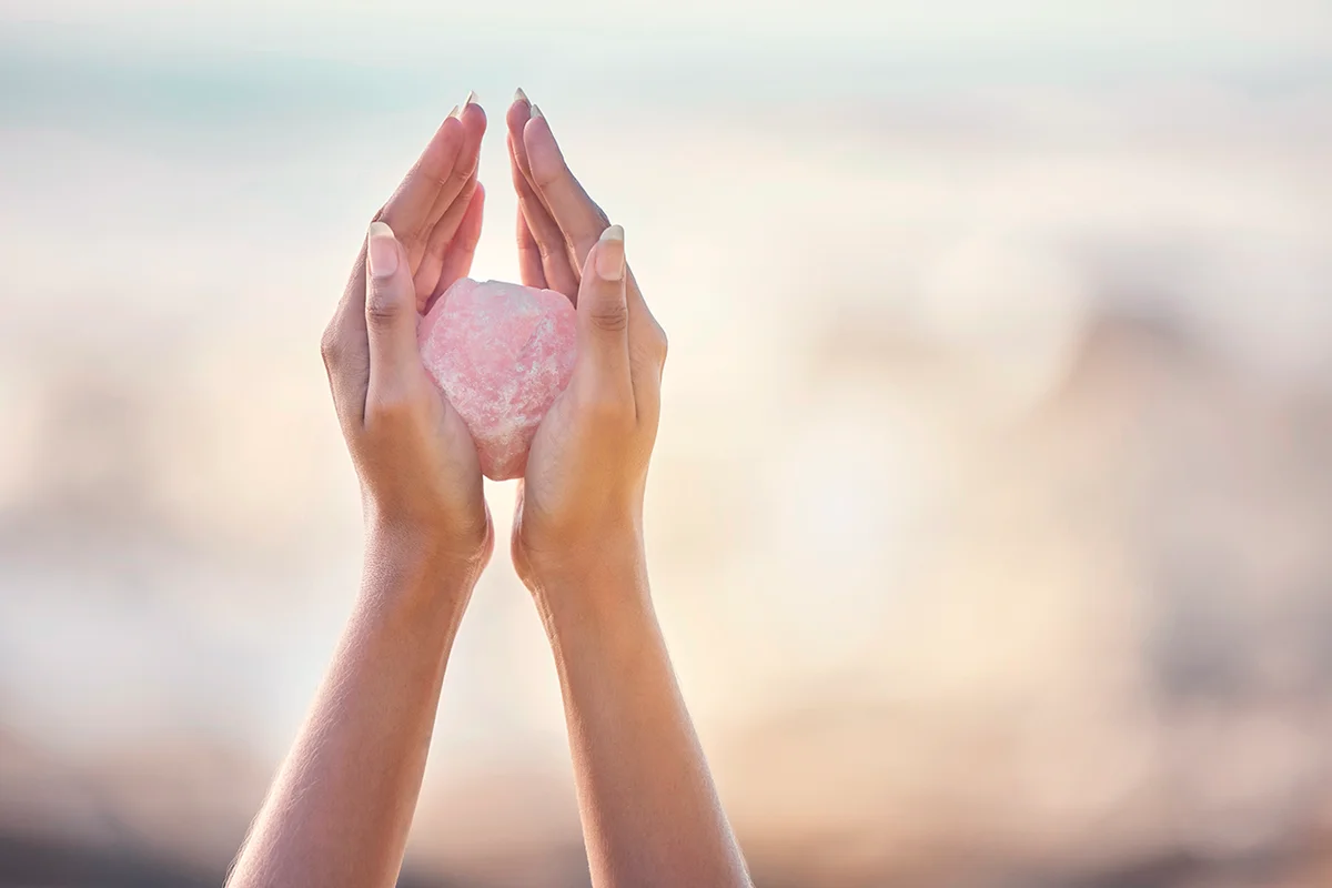 Woman, crystal hands and outdoor healing in nature for zen wellness, mindfulness or peace with spirit rock. Energy stone, rose quartz or calm spiritual meditation for growth, health or relax for girl