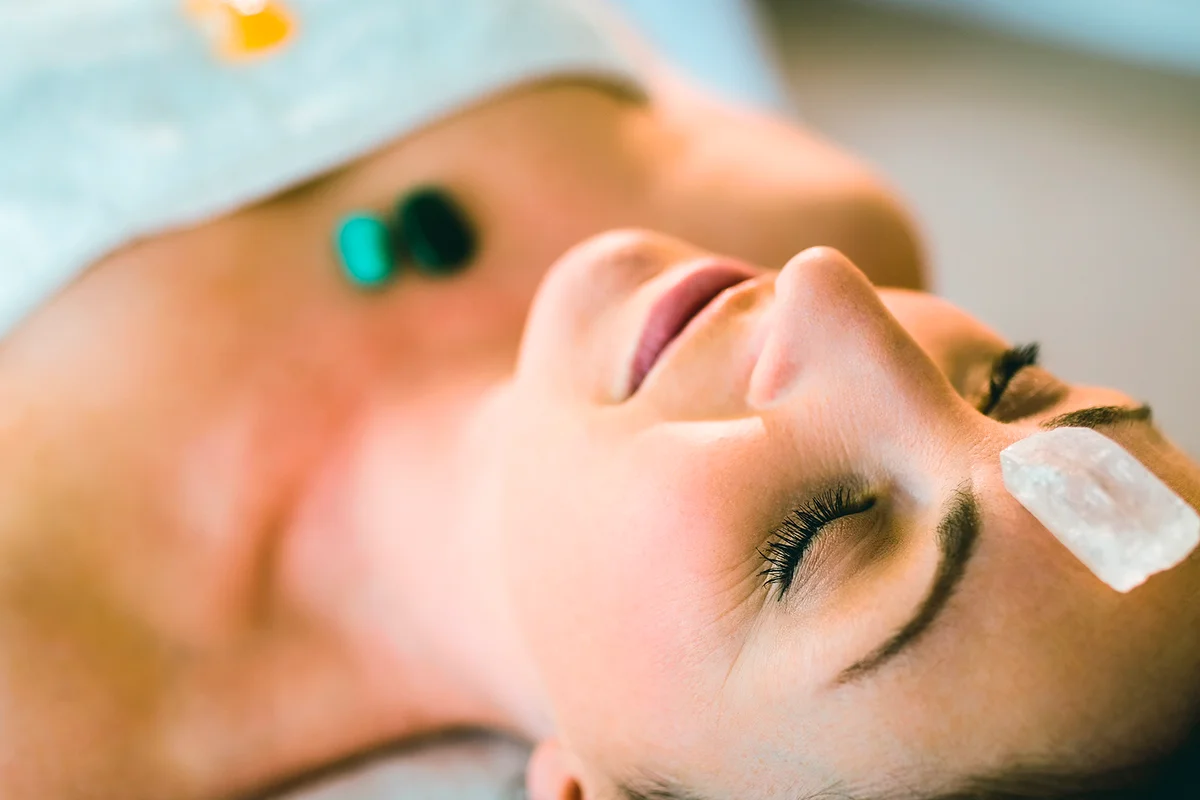 Close up of young woman at crystal healing session in therapy room