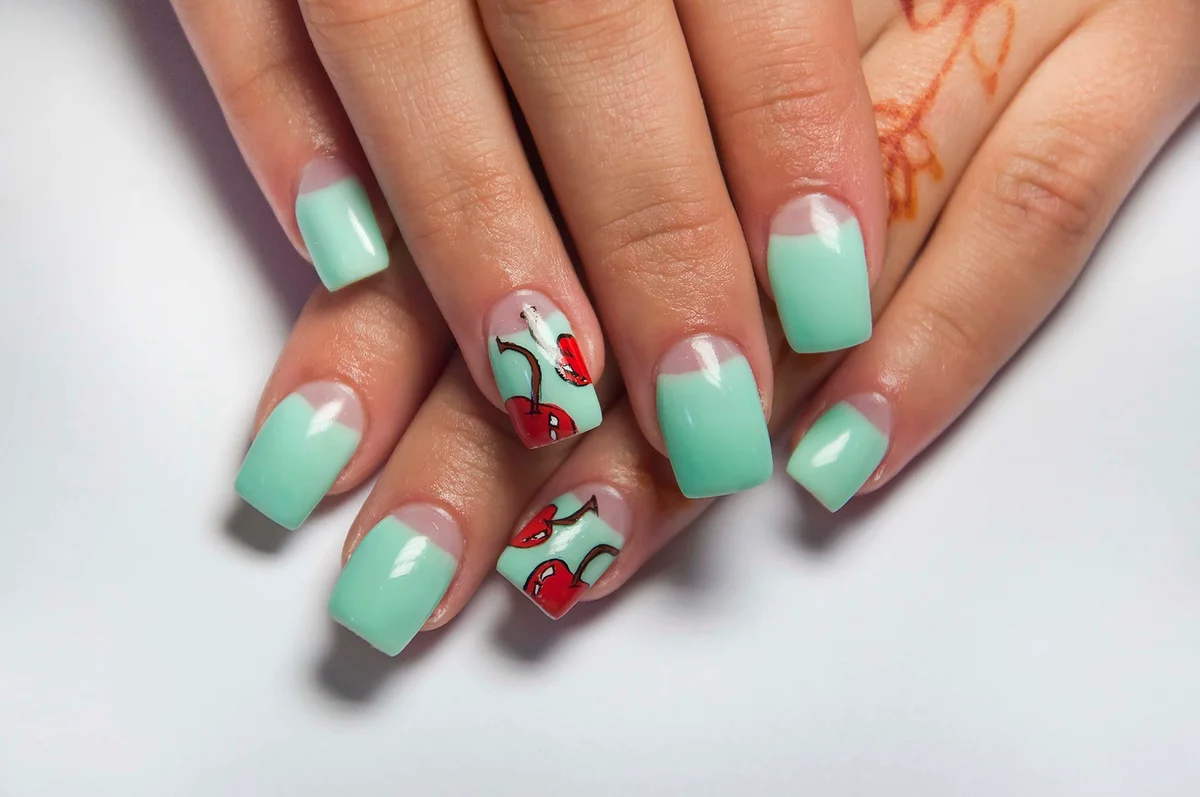 Summer mint manicure with cherries on the ring finger on the square long nails