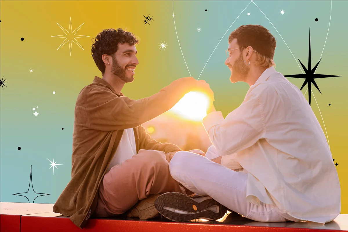 smiling couple holding hands while sitting and looking at each other