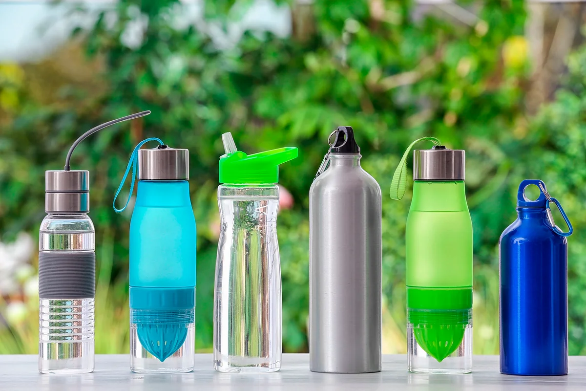 Sports water bottles on table against blurred background