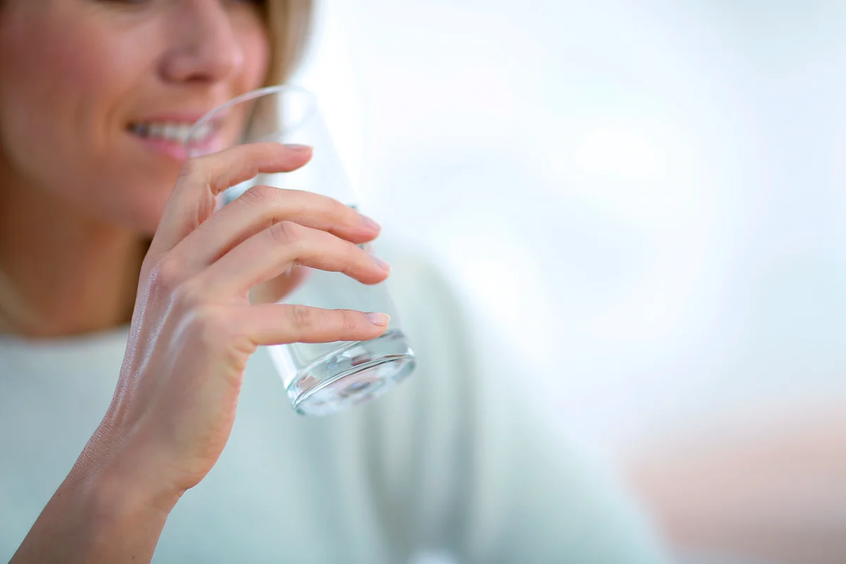 Closeup on glass of water held by woman's hand