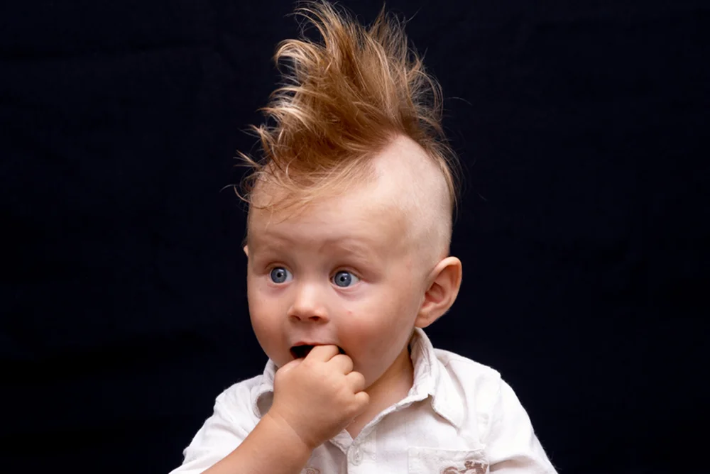 Cute blonde gothic baby boy with a mohawk hairstyle