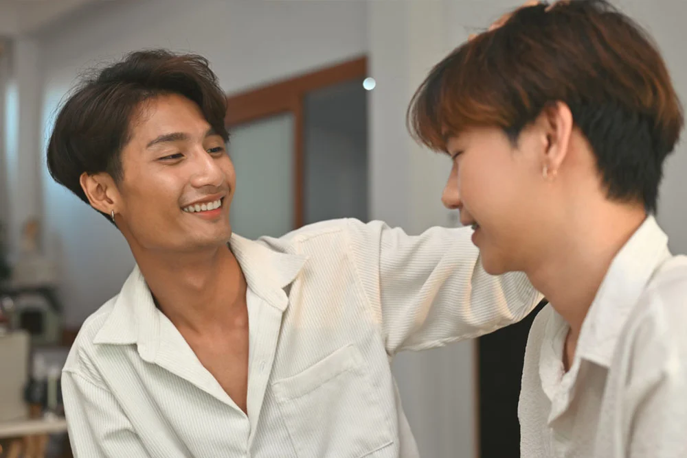 Asian young man touches his friend's head in a gentle loving way