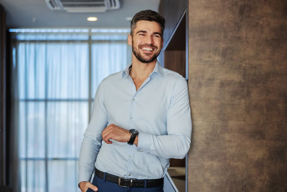Candid middle shot portrait of an attractive, elegant, caucasian man laughing in his home.