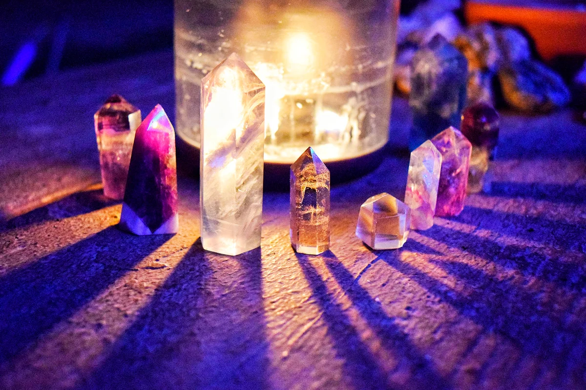 Glass towers around a candle casting shadows under a full moon.
