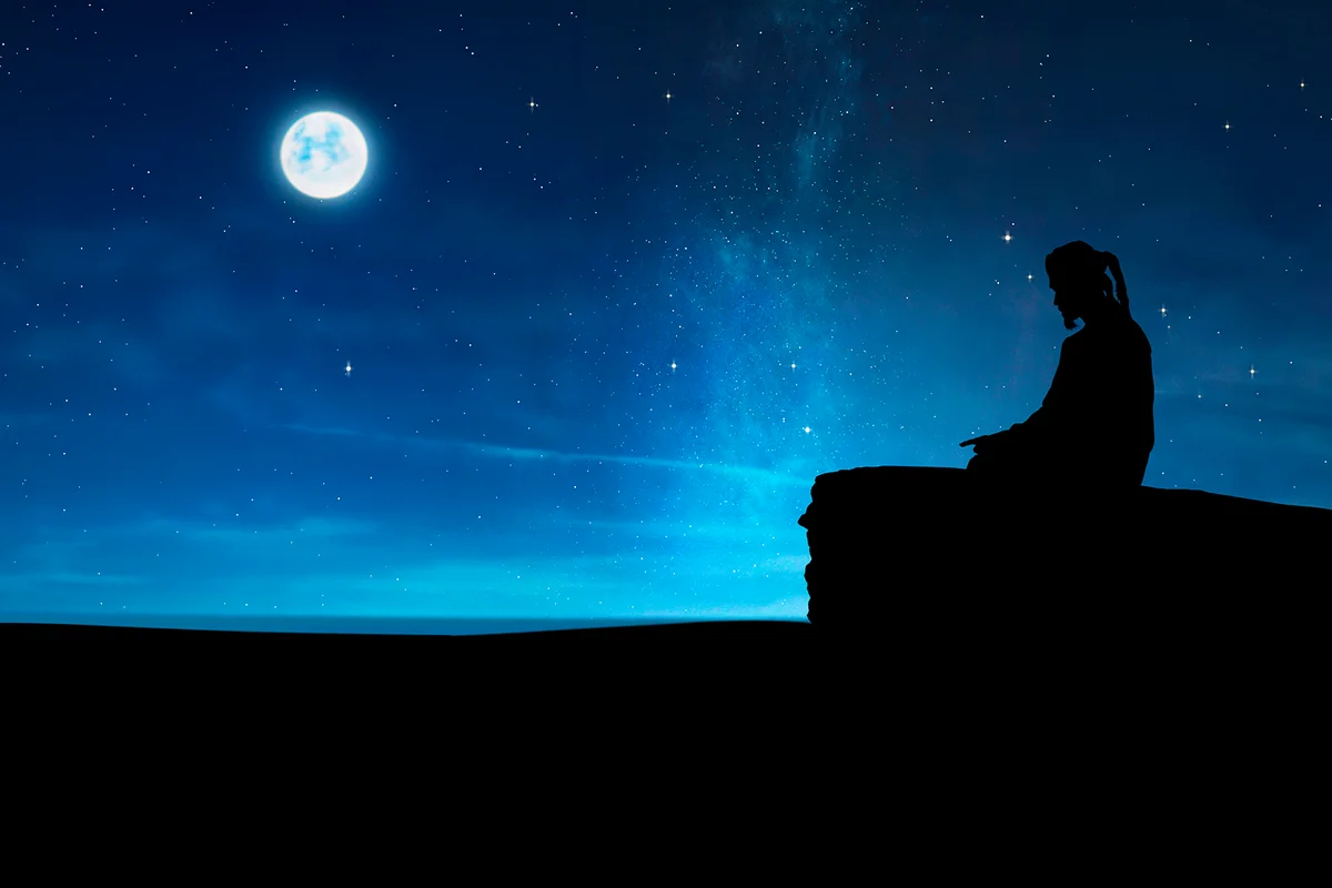 Silhouette of a Muslim praying at night