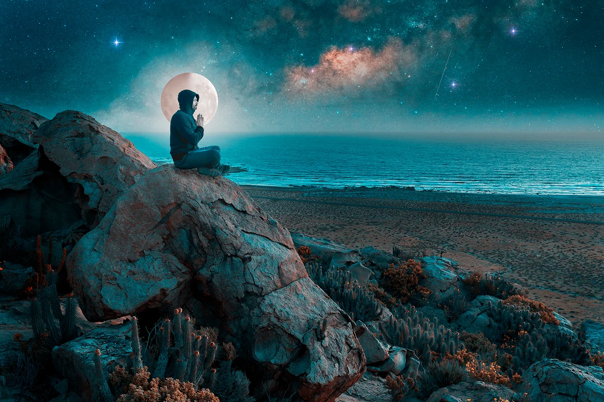 silhouette of a person meditating on a hill at night, in a milky way and on a full moon background