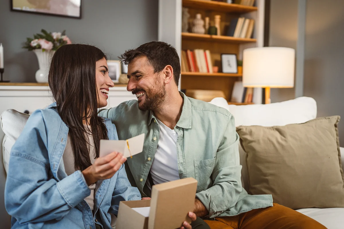 Couple read birthday card greetings together at home
