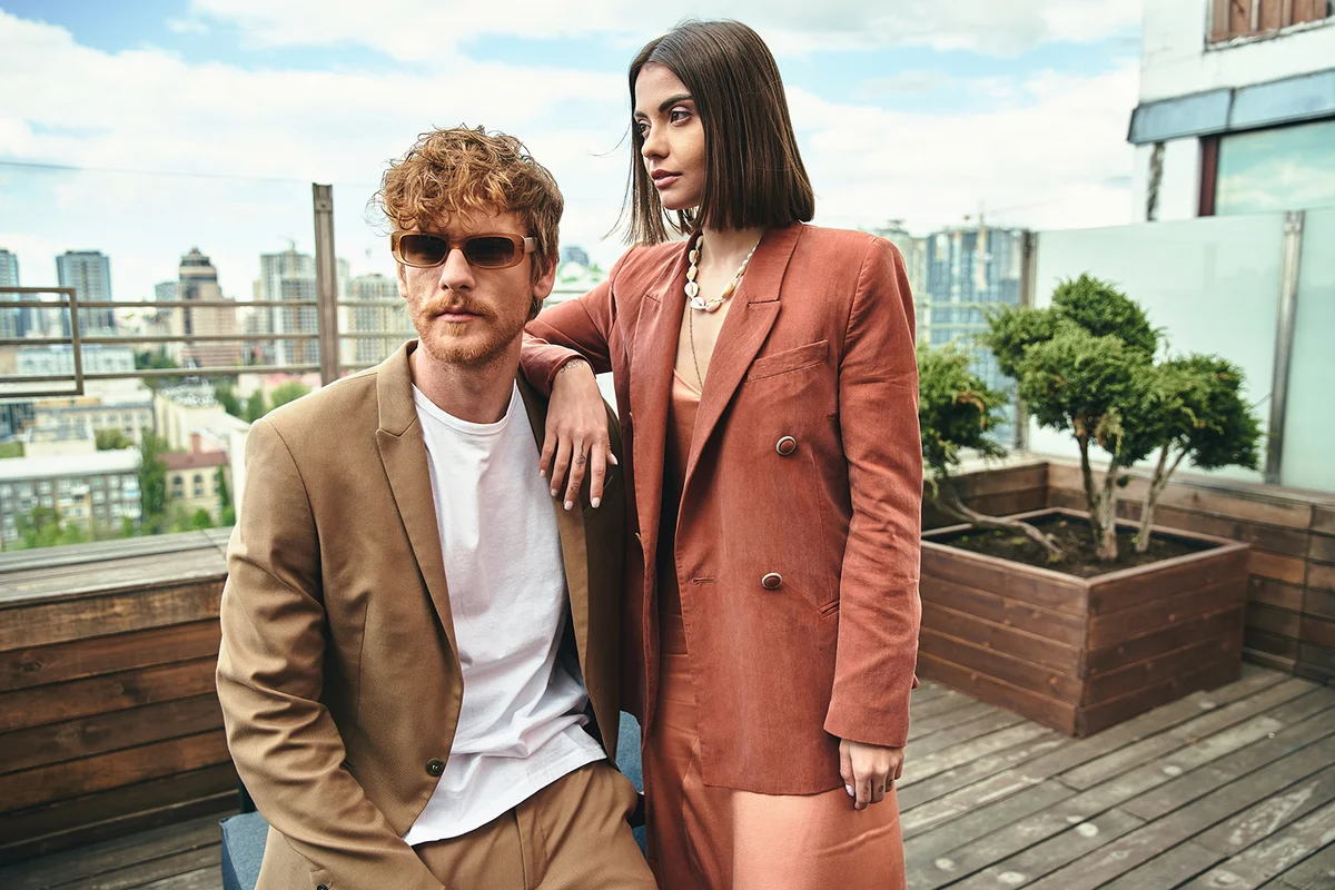 A stylish man and a fashionable woman striking a confident pose together, exuding elegance and charisma