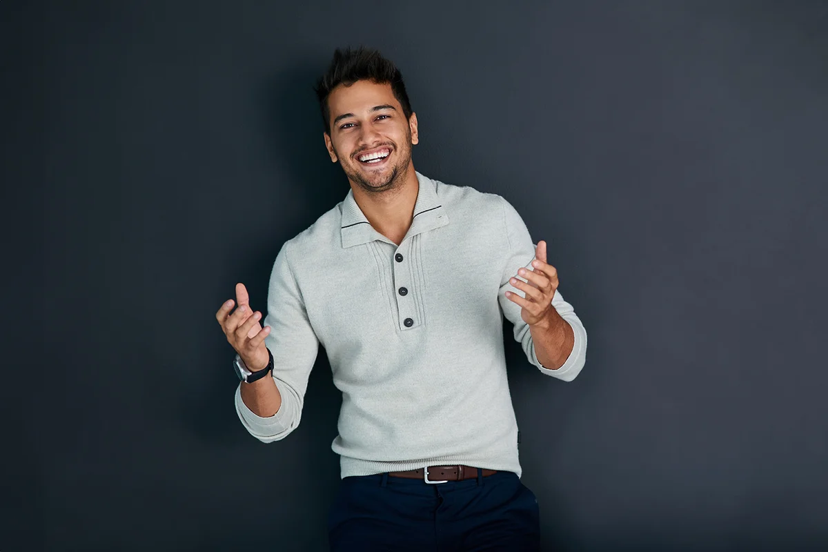 Portrait, laugh and man in studio, fashion and smile with laughing, confidence and proud of outfit.