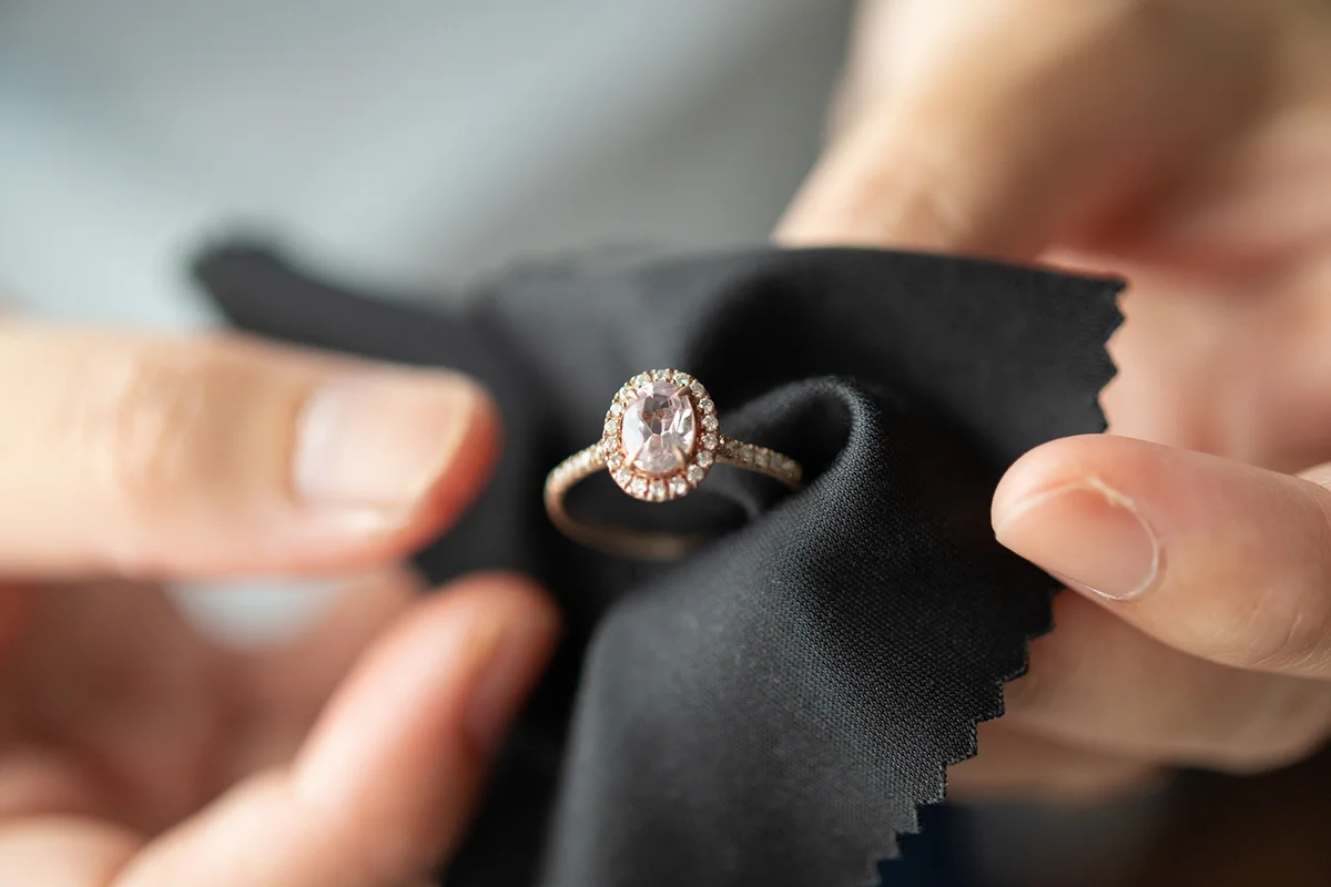 Jeweller cleaning jewelry diamond ring with fabric cloth
