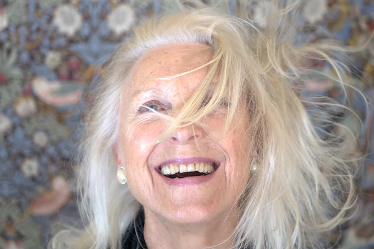 smiling older woman, with her white hair blowing